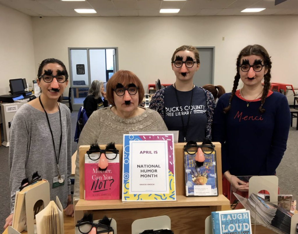 an image of Yardley staff librarians wearing funny eyeglasses in front of a display of books.