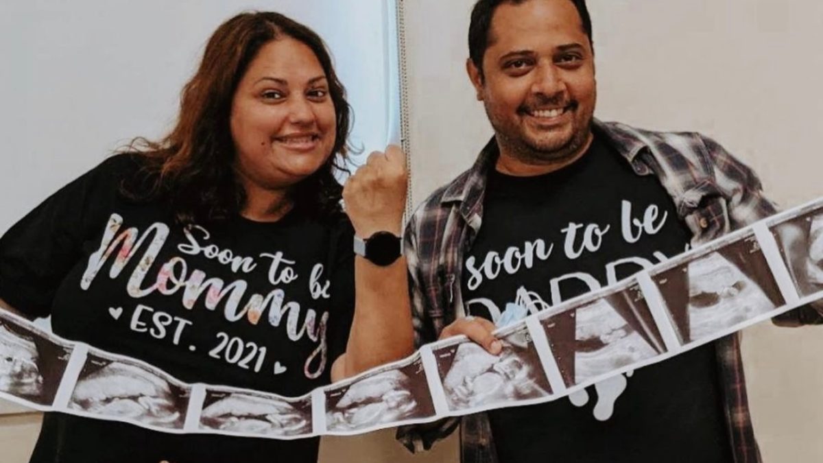 mom and dad to be holding ultrasound photos