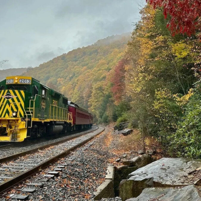 A Lehigh Gorge Scenic Railway train chugs past autumn foliage in the Poconos.