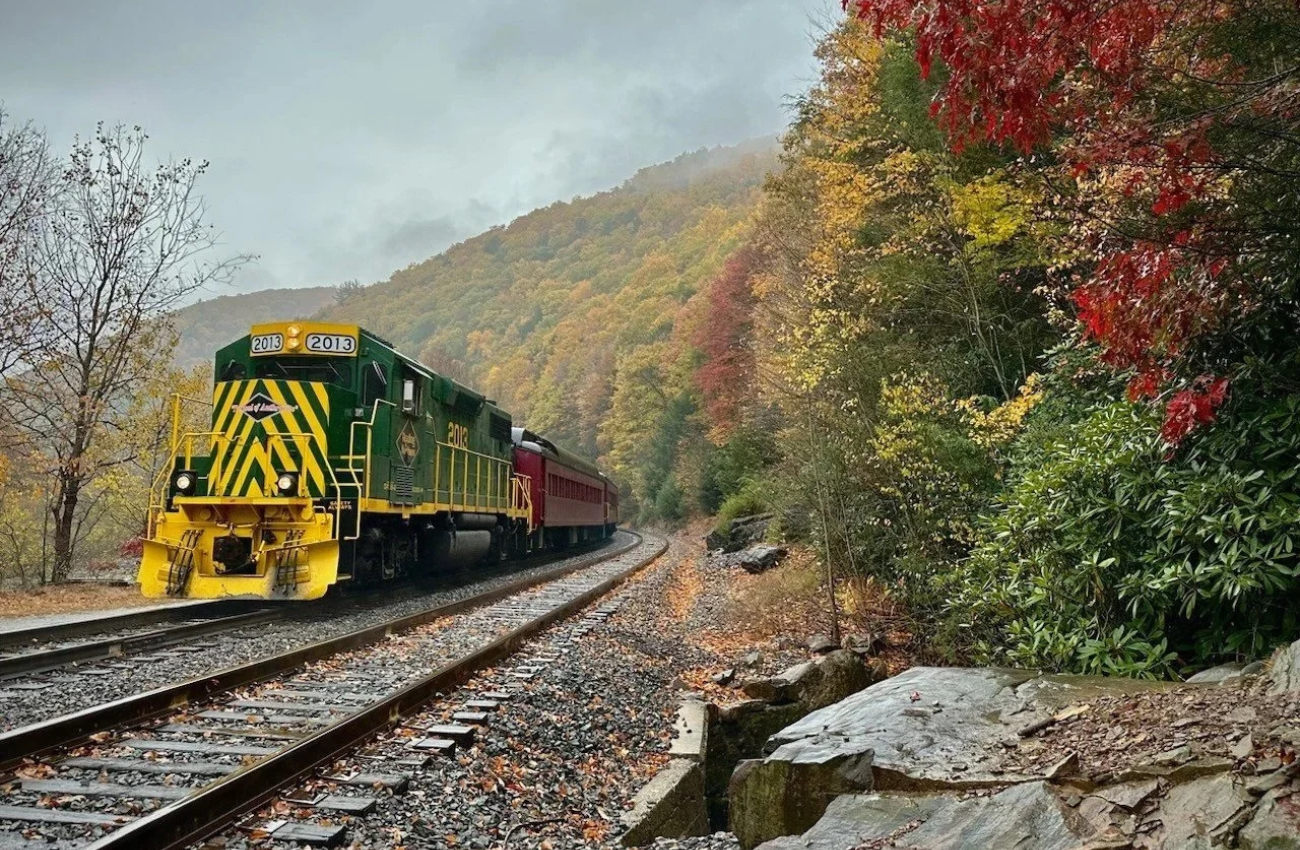 A Lehigh Gorge Scenic Railway train chugs past autumn foliage in the Poconos.