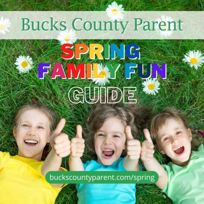 children laying in the grass with the words Bucks County Parent Spring Family Fun Guide laying over top of the image