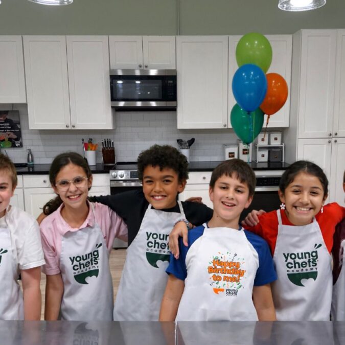 Six kids in apron pose at a birthday party at Young Chefs Academy Yardley.