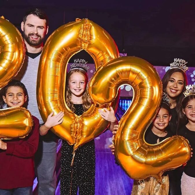 Parent and kids hold balloons for the new year at Bowlero Feasterville.
