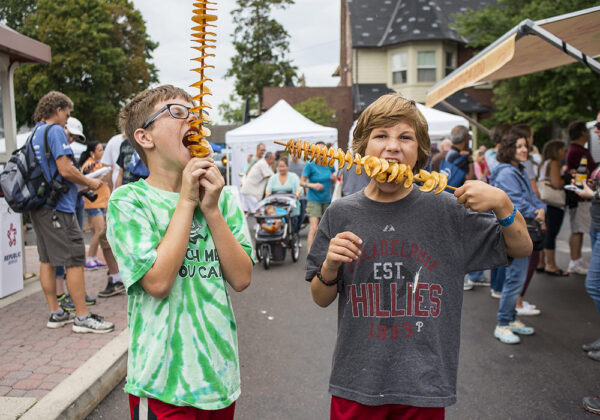 Two kids eat food at the Doylestown Arts Festival