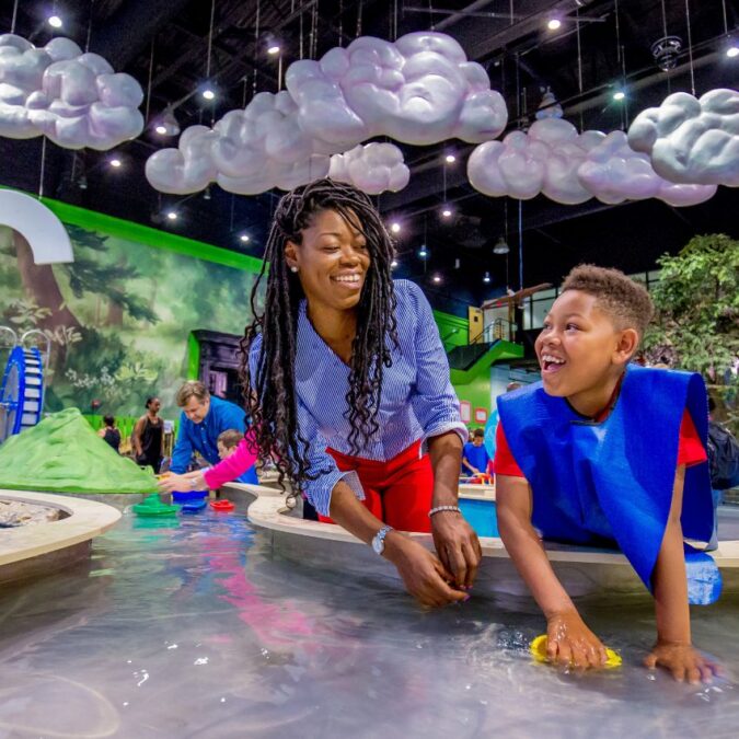 Mother and son play at a water table at the Please Touch Museum in Philadelphia