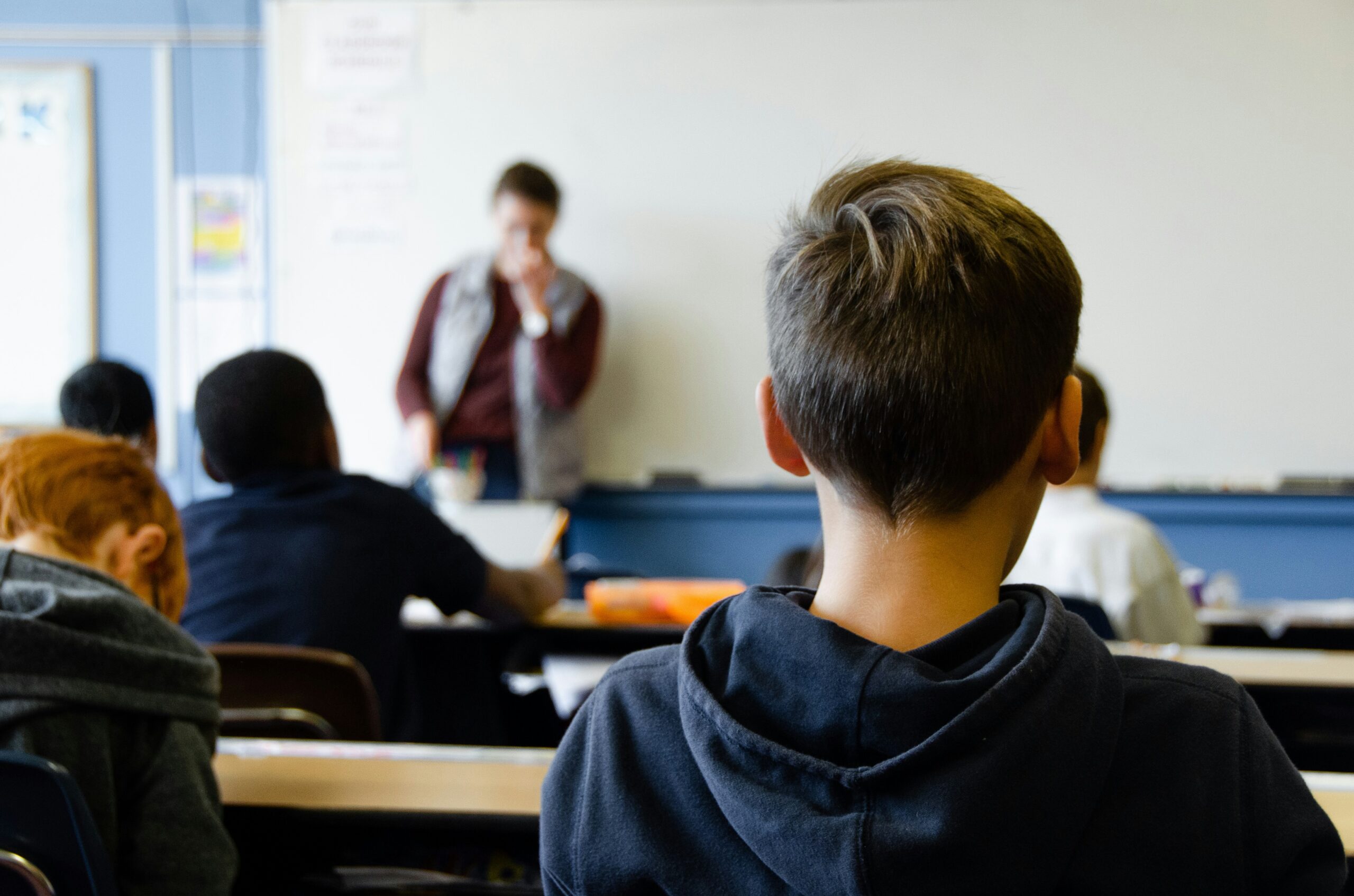 A student sits in the back of a high school classroom.